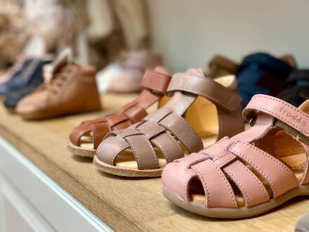 Close-up of children's sandals in various colors displayed at Fló shoes.