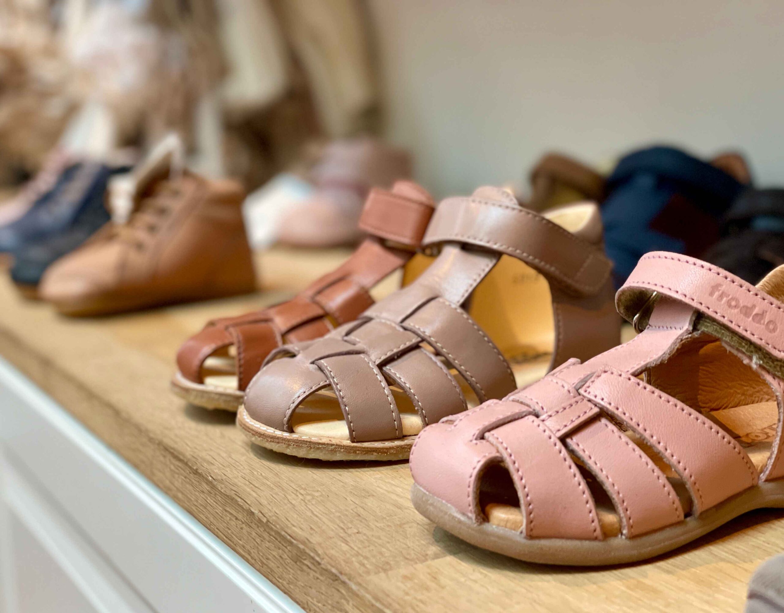 Close-up of children's sandals in various colors displayed at Fló shoes.