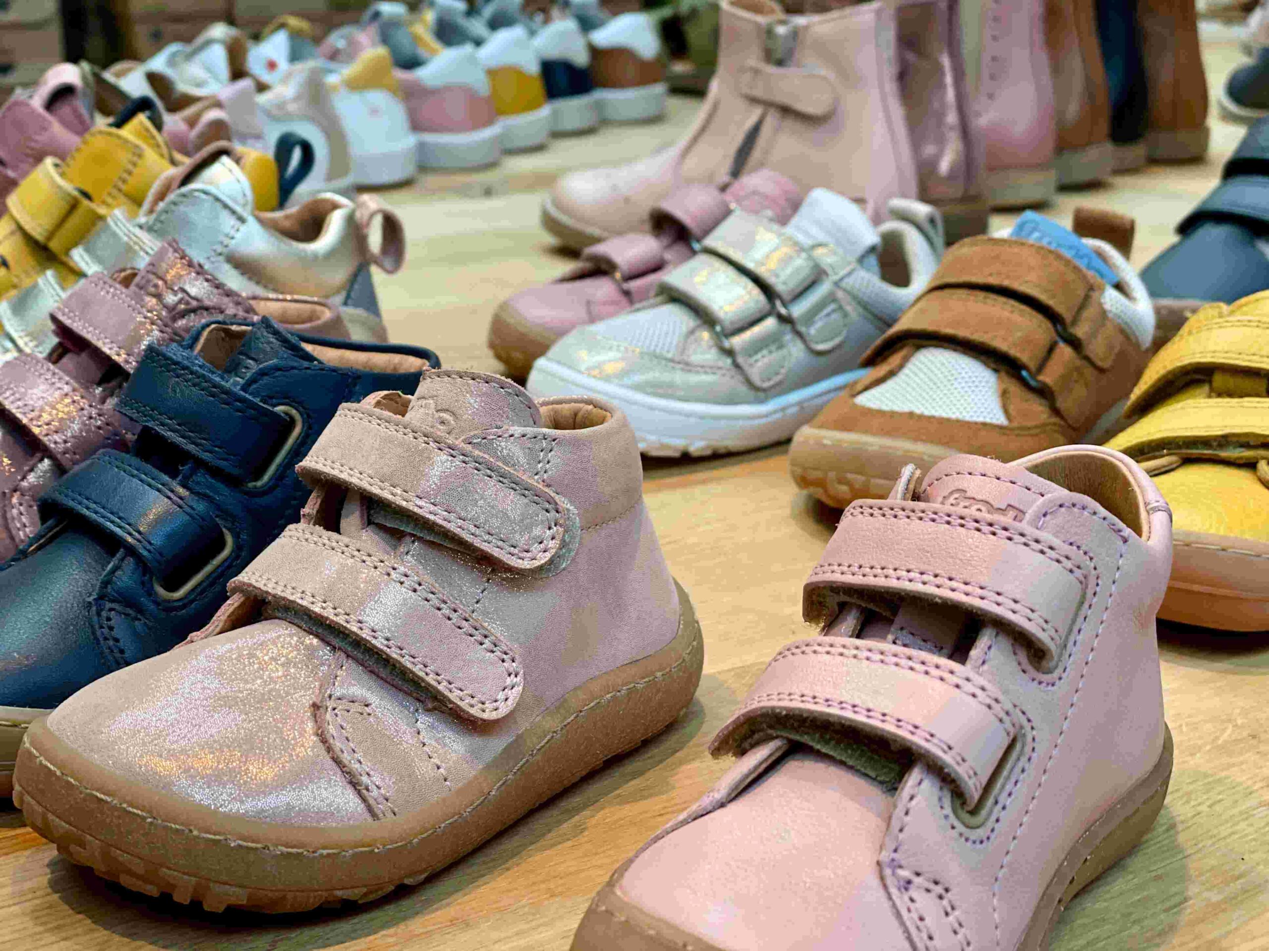 Assortment of Froddo Barefoot and First Step children's shoes in various colors, including pink and blue, at Fló shoes.
