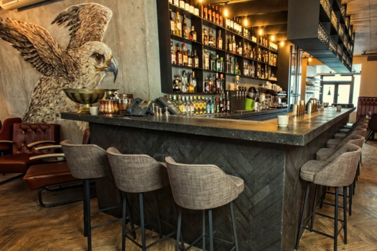 The interior of Kol Restaurant in Reykjavik, showcasing its stylish bar area with a wide selection of bottles and comfortable seating.