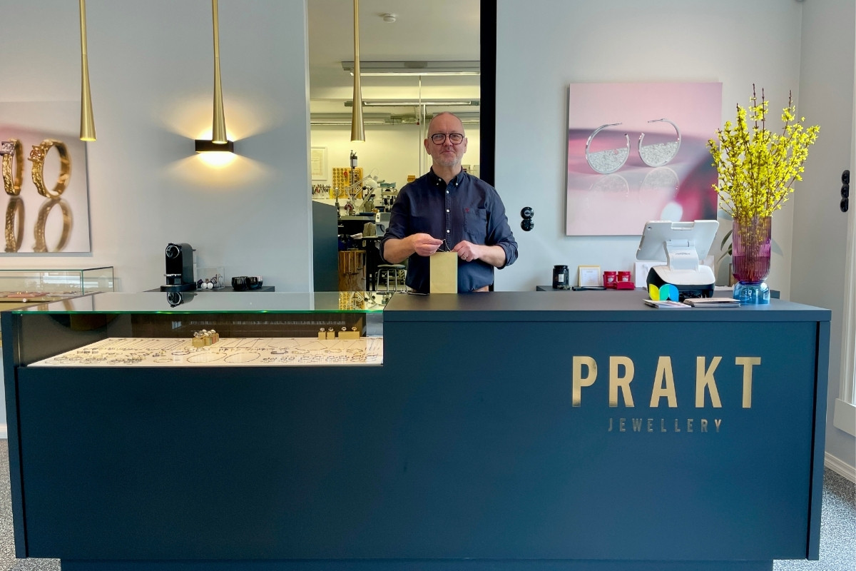 The interior of the Prakt Jewellery store in Reykjavik, showcasing the counter and a staff member assisting a customer.