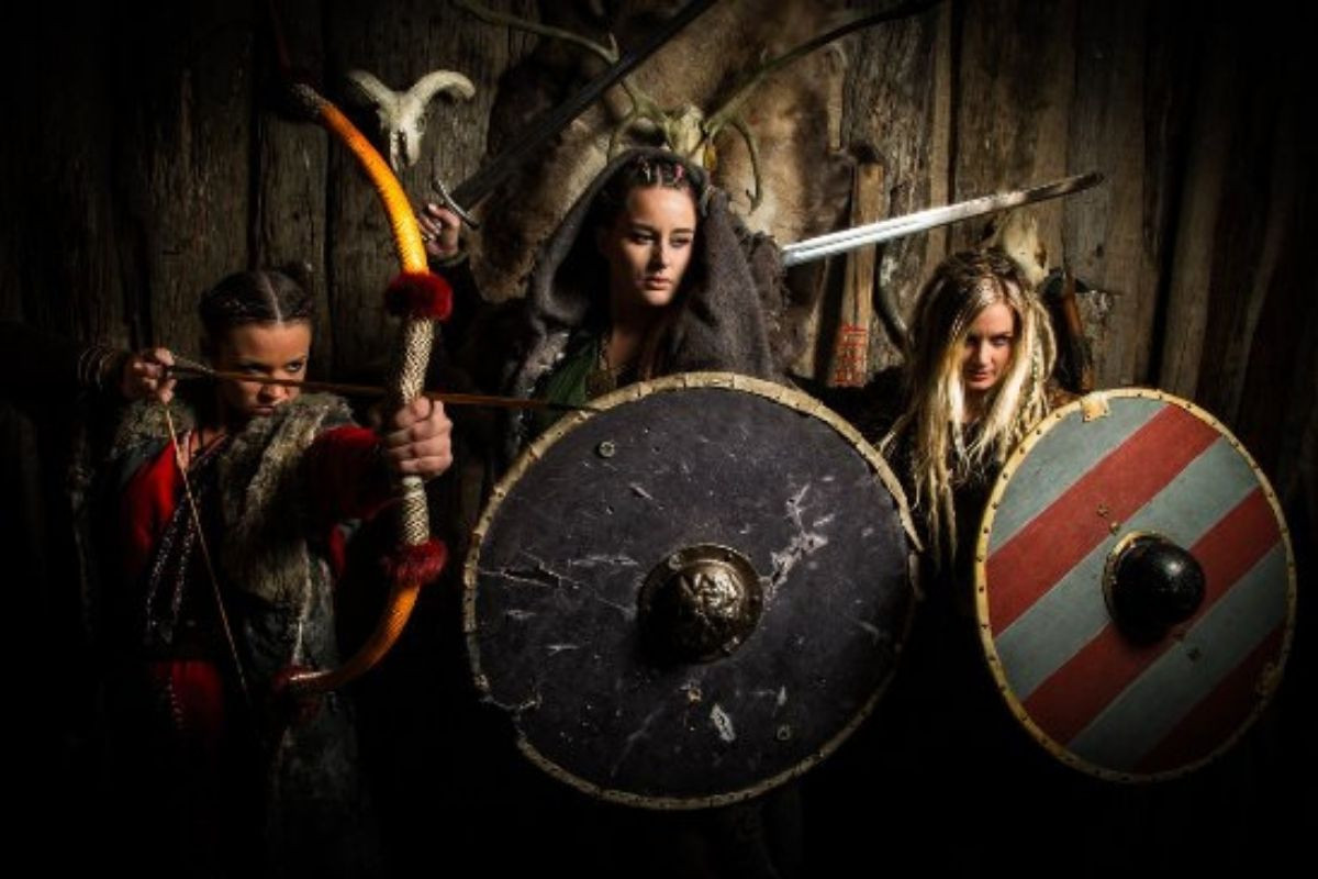 Three women dressed as Viking warriors with shields and weapons (bow and arrow, sword) at Mink Viking Portrait in Reykjavik.