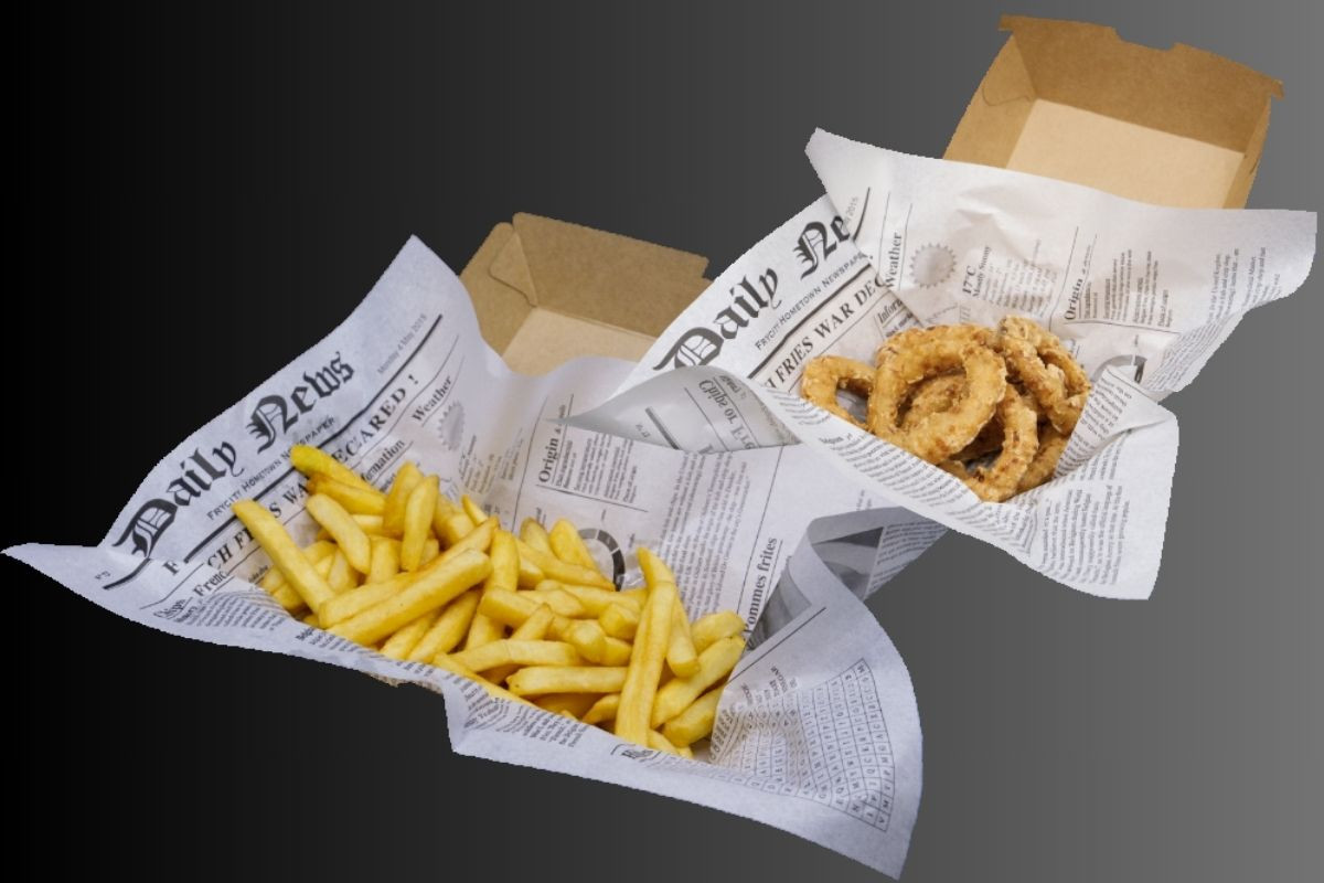 Two servings of takeout food, one with french fries and the other with onion rings, both presented in paper cones resembling newspaper.