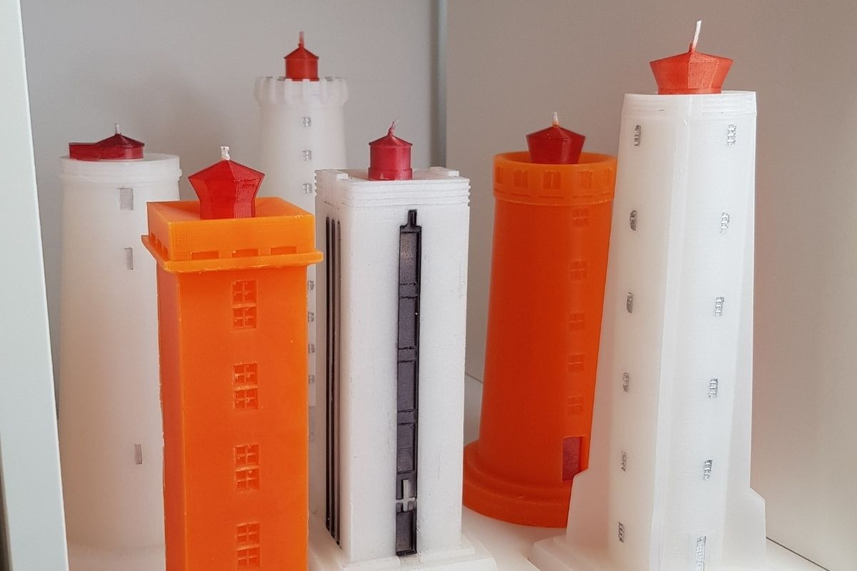 Kertahúsið's collection of lighthouse-shaped candles in white and orange with red tips.