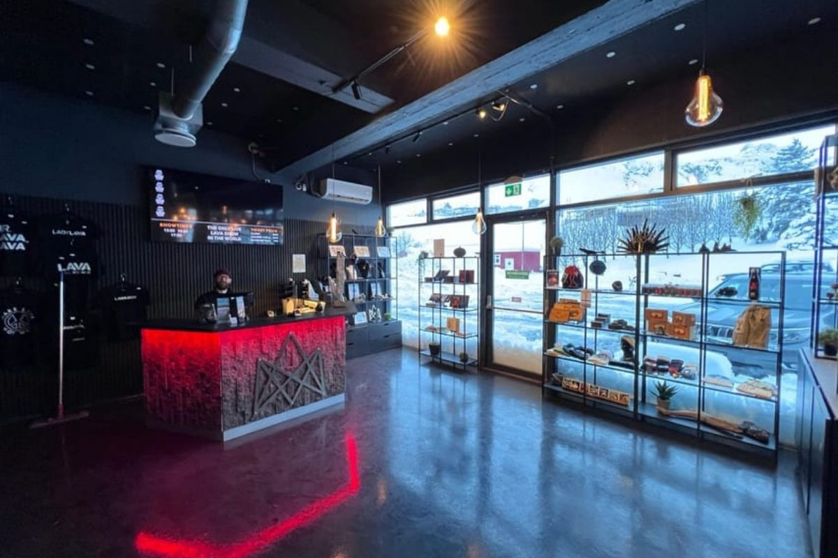 Interior of the Lava Show gift shop with a red illuminated counter, shelves of merchandise, and large windows.