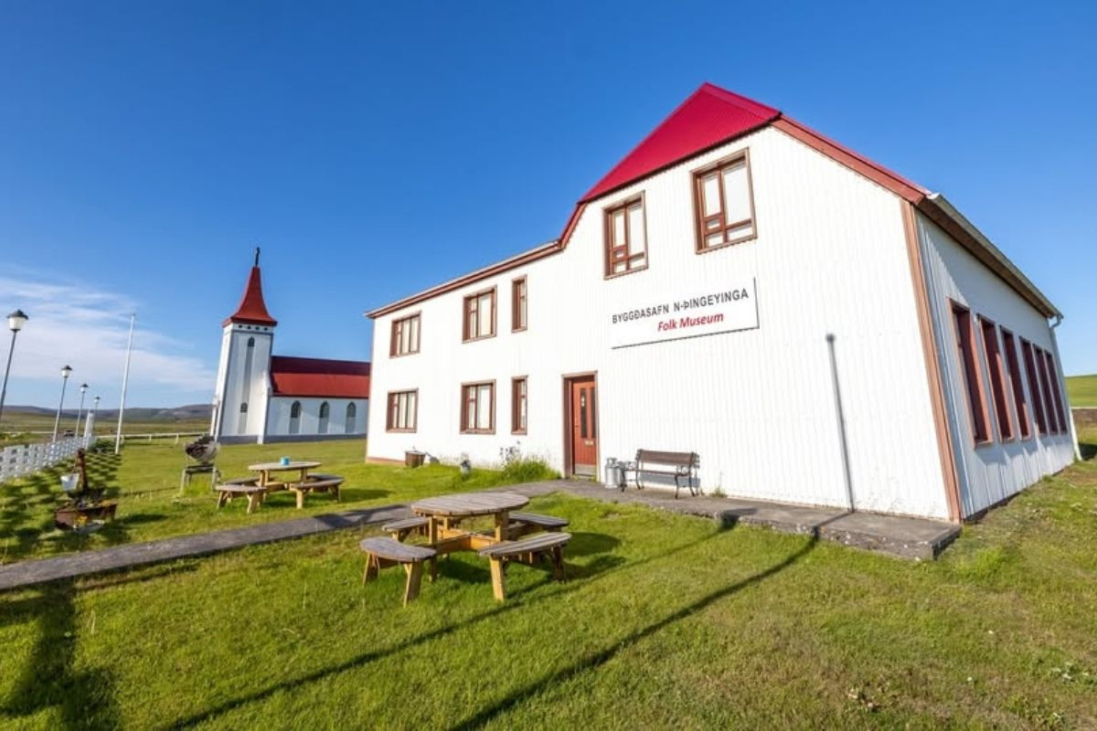 A bright white building with a red roof, labeled 